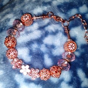 Rose gold snake chain charm bracelet with rose gold floral spacers and charms